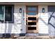 Modern front door with glass panes, sconces, and visible house number creates a welcoming entrance to this charming home at 555 W Peakview Ave, Littleton, CO 80120