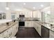 Bright kitchen with granite countertops, stainless steel appliances, and dark hardwood floors at 555 W Peakview Ave, Littleton, CO 80120