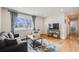 Cozy living room with a plush sofa, decorative rug, and view to the front yard at 8331 Mason Cir, Westminster, CO 80031