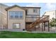 Backyard with home exterior featuring a deck with stairs, green grass, and gravel at 2668 Scoter Ln, Castle Rock, CO 80104