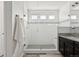 Modern bathroom with glass shower, white tile, and granite countertop with wood cabinets at 2668 Scoter Ln, Castle Rock, CO 80104