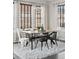 Bright dining area is complete with stylish table and chairs set on a plush rug, lit by a modern chandelier at 2668 Scoter Ln, Castle Rock, CO 80104