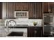 Contemporary kitchen features stainless steel appliances, granite counters, and dark wood cabinetry at 2668 Scoter Ln, Castle Rock, CO 80104