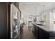 View of open concept kitchen flowing into living area with stainless steel appliances and dark cabinetry at 2668 Scoter Ln, Castle Rock, CO 80104