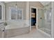 Bright bathroom with a soaking tub, glass-enclosed shower, and picture window at 7114 Mountain Brush Cir, Highlands Ranch, CO 80130