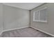 Small bedroom with a window and neutral gray walls and carpet at 7114 Mountain Brush Cir, Highlands Ranch, CO 80130