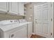 Laundry room featuring white appliances and storage cabinets at 7114 Mountain Brush Cir, Highlands Ranch, CO 80130