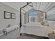 Elegant main bedroom featuring a cathedral window, four-poster bed, bench, and a bright and airy feel at 7114 Mountain Brush Cir, Highlands Ranch, CO 80130