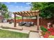 Outdoor patio area with pergola, comfortable seating, garden beds, and manicured lawn for relaxing or entertaining at 11855 Humboldt Dr, Northglenn, CO 80233