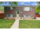 Charming two-story brick home with lush green lawn, tidy garden beds, and bright green shutters at 11855 Humboldt Dr, Northglenn, CO 80233