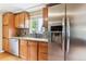 The kitchen showcases stainless steel refrigerator, granite countertops, and wooden cabinets at 11855 Humboldt Dr, Northglenn, CO 80233