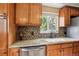 Kitchen boasting granite countertops, stainless steel dishwasher, and a window view at 11855 Humboldt Dr, Northglenn, CO 80233