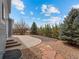 The backyard features a stone patio and lush landscaping providing privacy and outdoor enjoyment at 306 Monares Ln, Erie, CO 80516