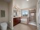 A bright bathroom featuring a double vanity, a separate shower, and a soaking tub with a view at 306 Monares Ln, Erie, CO 80516