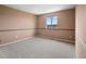 Spacious bedroom featuring neutral paint, gray carpet, and a window with neighborhood views at 306 Monares Ln, Erie, CO 80516