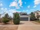 Exterior view of a charming home featuring a gray two-car garage and a well-kept lawn at 306 Monares Ln, Erie, CO 80516
