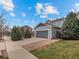 Charming home with a two-car garage, manicured lawn, and sidewalk at 306 Monares Ln, Erie, CO 80516