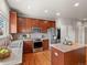 Updated kitchen featuring stainless steel appliances, stylish backsplash, and a practical center island at 306 Monares Ln, Erie, CO 80516