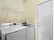 Convenient laundry area with modern washer and dryer, storage shelf, and access door at 306 Monares Ln, Erie, CO 80516