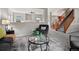 Open-concept living room features a cozy armchair, a stylish rug, and a staircase with wood railings in the background at 306 Monares Ln, Erie, CO 80516