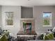Cozy living room features a tiled fireplace, comfortable seating arrangement, and large windows offering natural light at 306 Monares Ln, Erie, CO 80516