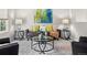 Comfortable living room with stylish gray sofa, colorful pillows, and a glass coffee table complemented by modern side tables at 306 Monares Ln, Erie, CO 80516