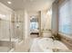 The spa-like bathroom features a soaking tub and a glass-enclosed shower with a view of the main bedroom at 1788 Holmby Ct, Castle Rock, CO 80104