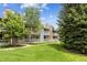 Beautiful condo exterior featuring stone accents, a balcony, and manicured lawn at 8335 Fairmount Dr # 9-201, Denver, CO 80247