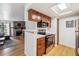 Open kitchen with stainless appliances, stone fireplace visible from the adjacent living area at 8335 Fairmount Dr # 9-201, Denver, CO 80247