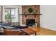 Cozy living room features a stone fireplace, hardwood floors, and ample natural light at 8335 Fairmount Dr # 9-201, Denver, CO 80247