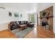 Inviting living room featuring hardwood floors, a stone fireplace, and a sliding glass door at 8335 Fairmount Dr # 9-201, Denver, CO 80247