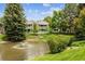 Scenic view of a pond with a fountain, surrounded by lush greenery and a building with balconies at 8335 Fairmount Dr # 9-201, Denver, CO 80247