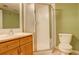 Clean bathroom with shower stall, toilet and wood vanity at 1885 S Quebec Way # L102, Denver, CO 80231
