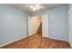 Bedroom with light blue walls, wood floors, and access to stairs at 1885 S Quebec Way # L102, Denver, CO 80231