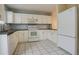 Galley kitchen with white cabinets and tiled floor at 1885 S Quebec Way # L102, Denver, CO 80231