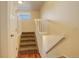 Carpeted staircase with white railing leading to upper level at 1885 S Quebec Way # L102, Denver, CO 80231