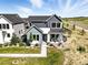 Beautiful two-story home featuring a landscaped front yard, modern design, and welcoming entryway at 6235 Stable View St, Castle Pines, CO 80108