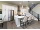 Modern kitchen with white cabinets, stainless steel appliances, hardwood floors and bar seating at 6235 Stable View St, Castle Pines, CO 80108