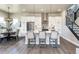 Modern kitchen with stainless steel appliances, pendant lighting, white cabinets and hardwood floors at 6235 Stable View St, Castle Pines, CO 80108