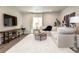 Inviting living room features a plush sectional sofa, rustic wood media console, and a soft white rug at 6235 Stable View St, Castle Pines, CO 80108