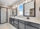 Modern bathroom with black fixtures, white quartz countertops, glass shower, and light tile flooring at 3314 N Haleyville Ct, Aurora, CO 80019