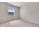 This bright bedroom has neutral walls and carpet, plus a window with a neighborhood view at 3314 N Haleyville Ct, Aurora, CO 80019