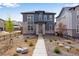 Beautiful two-story home with gray siding, stone accents, manicured landscaping, and inviting walkway to the front door at 3314 N Haleyville Ct, Aurora, CO 80019