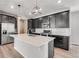 Well-appointed kitchen with dark cabinets, quartz countertops, island, and stainless steel appliances for modern living at 3314 N Haleyville Ct, Aurora, CO 80019