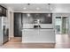 Modern kitchen featuring dark cabinets, quartz countertops, subway tile backsplash, stainless steel appliances, and pendant lights at 3314 N Haleyville Ct, Aurora, CO 80019