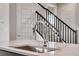 Modern kitchen island with a sink and a view of the staircase at 3314 N Haleyville Ct, Aurora, CO 80019