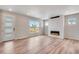 Bright living room featuring hardwood floors, fireplace, modern lighting, and large windows offering neighborhood views at 3314 N Haleyville Ct, Aurora, CO 80019