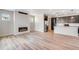 Modern living area with hardwood floors, fireplace, and adjacent kitchen with stainless steel appliances at 3314 N Haleyville Ct, Aurora, CO 80019