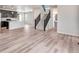 Open-concept living area with hardwood floors and staircase leading to a modern kitchen and dining space at 3314 N Haleyville Ct, Aurora, CO 80019