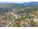 Aerial view of a home nestled among trees with mountain views at 3173 Gold Yarrow Ln, Evergreen, CO 80439